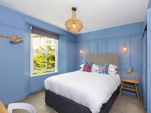 法尔茅斯The Broadmead的蓝色的卧室设有床和窗户