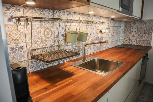布达佩斯Baleo50 Apartment的厨房配有水槽和木制台面