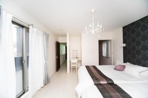 今津Shiga Lakeside Villa的一间卧室配有一张大床和一个吊灯。