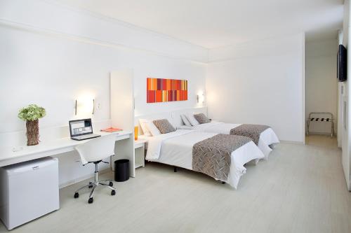 贝洛奥里藏特大道广场酒店的一间白色卧室,配有两张床和一张书桌