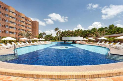 巴雷里尼亚斯Gran Lençois Resort的度假村内的大型游泳池配有椅子和遮阳伞