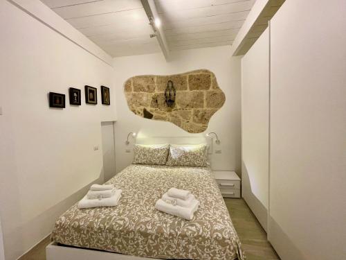 阿尔盖罗Protea House的一间卧室配有一张床,上面有两条毛巾