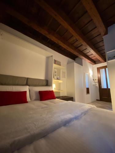 贝加莫Domus Solarii Holiday Home的卧室配有带红色枕头的大型白色床