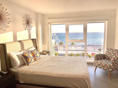 奥拉涅斯塔德Ocean View Condo overlooking the Caribbean Sea的一间卧室配有一张床,享有海景