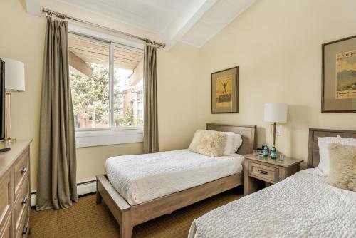 阿斯潘Standard 2 Bedroom - Aspen Alps #115的一间卧室设有两张床和窗户。