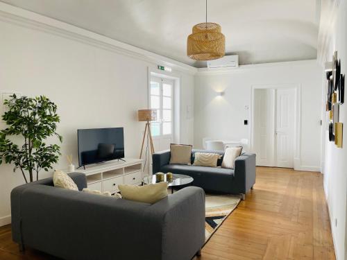 埃武拉Casa Soure Suites and Apartments的客厅配有两张沙发和一台电视机