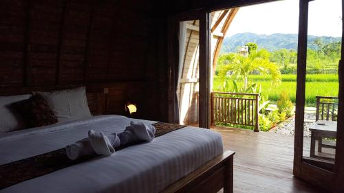 班尤温当Umma Bali Menjangan Retreat的卧室配有一张床,享有庭院的景色