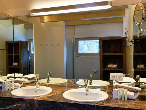 施利尔塞Ferienhaus Alpenflair bei Schliersee的一间带三个水槽和大镜子的浴室