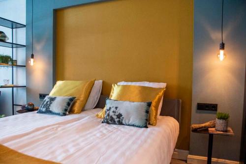 霍林赫姆B and B Suite No.3的一间卧室配有一张大床,提供黄色和蓝色的枕头