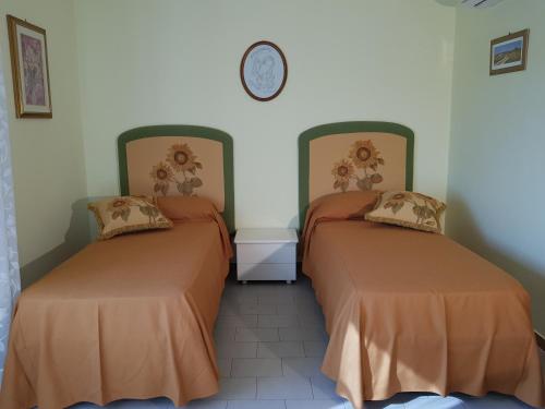 圣欧费米亚拉默齐亚Top bedroom GOLFO - Le Lincelle, Lamezia - 2 extra large single beds的墙上挂钟的房间里设有两张床
