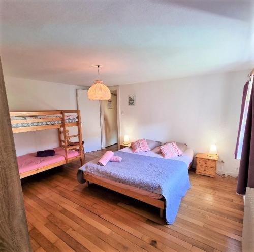 旺特龙Gite Myrtille 2 à 6 personnes dans Residence des Buis avec Spa的一间卧室配有两张床和一张双层床。