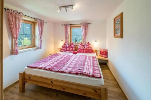 约赫贝格Biohof Vorderreith的一间卧室配有一张带粉红色床单的大床