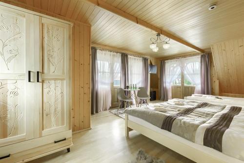 维托韦Góralska rezydencja的一间卧室设有一张大床和木墙