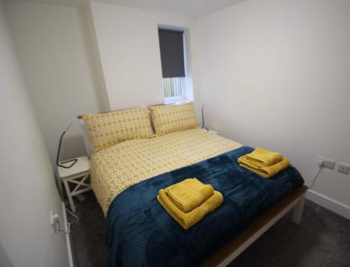牛顿阿伯特The Garden Apartment的一间卧室配有一张带两张黄色毛巾的床