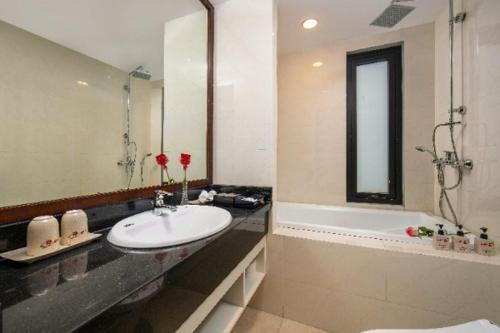 河内PING DIAMOND HOTEL的浴室配有盥洗盆和浴缸。