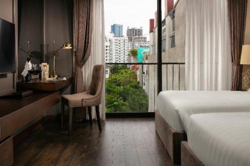 河内PING DIAMOND HOTEL的配有一张床、一张书桌和一扇窗户的酒店客房