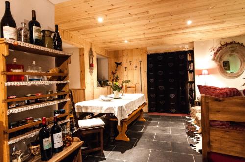 圣莫里斯堡塔利亚乐小木屋酒店的用餐室配有桌子和瓶装葡萄酒