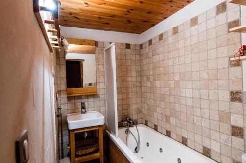 圣莫里斯堡塔利亚乐小木屋酒店的浴室配有盥洗盆和浴缸。