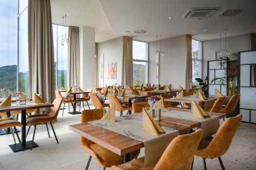 维斯瓦Crystal Mountain Hotel Wisła的餐厅设有桌椅和大窗户。