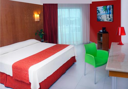 坎昆Adhara Express的酒店客房,配有一张床和一把绿色椅子
