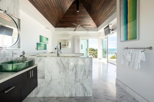 普罗维登西亚莱斯岛SulMare at Sapodilla Bay Luxury villas的一间带大型大理石盥洗盆和淋浴的浴室