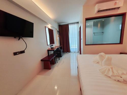 素叻SUhotel Suratthani的酒店客房的墙上设有大屏幕平面电视。