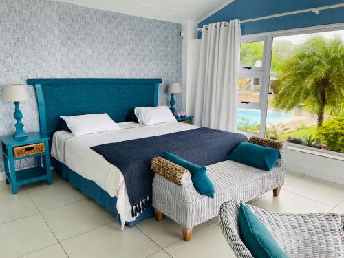 Freeland ParkThE LaZy ShArK的一间卧室配有一张蓝色的床、椅子和窗户