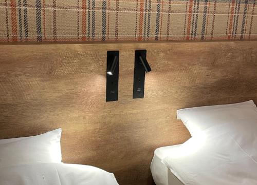 岐阜hotel the textile的一间卧室设有两张床,墙上设有两个音箱。