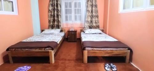 大吉岭Pema lhamu homestay的带窗户的客房内的两张床