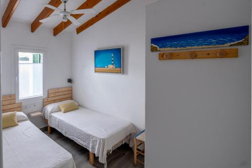 松霍里吉尔Apartamento con piscina y playa的客房设有两张床和吊扇。