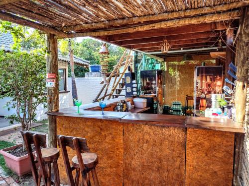 巴拉格兰德Pousada Barra del Mundo的木柜台上带三把凳子的酒吧