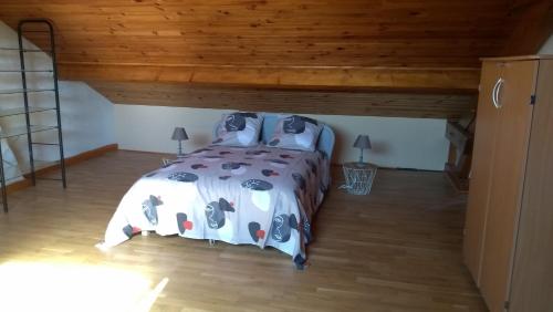 Saint-Loup-GéangesLA PETITE MAISON的一间卧室设有一张床和木制天花板