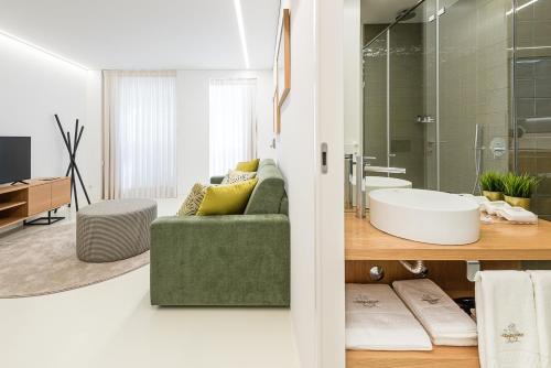 孔迪镇Lidador 116 Apartments的一间带绿色沙发和玻璃淋浴的浴室