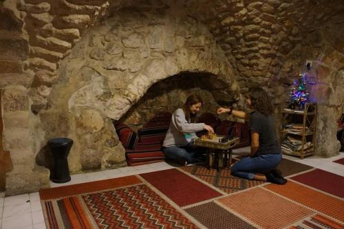 耶路撒冷New Citadel Hostel的两个人在石头房玩游戏