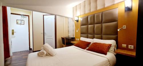 巴黎法兰西18号酒店的卧室配有带橙色枕头的大型白色床