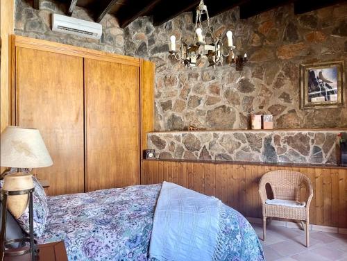 圣卢西亚casa rural LA LIMERA con piscina privada的一间卧室设有一张床和石墙
