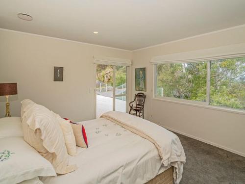 怀蒂昂格Hosts on the Coast Puriri Pride的白色的卧室设有床和窗户