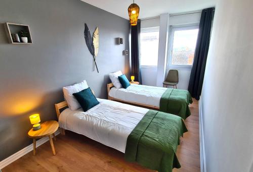 马孔Appartement Mâcon Centre T4 - 100m2的一间卧室设有两张床、一张桌子和一个窗口