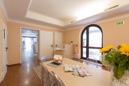 朱利亚诺瓦Ristorante Hotel Lucia - 100 mt dal mare的用餐室,配有花瓶桌子