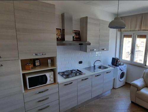 塔兰托Casatua的厨房配有白色橱柜、水槽和微波炉
