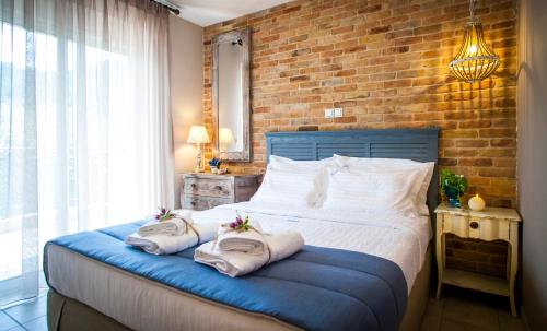 萨索斯Villa Teresa Luxury Suites的一间卧室配有带毛巾的床