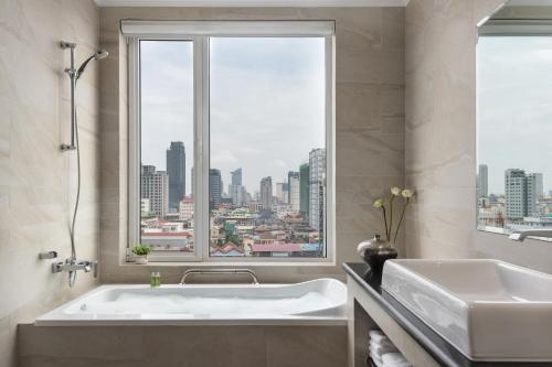 金边Duong Chan Hotel的带浴缸的浴室和大窗户