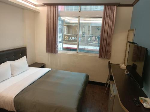 台东假期商务旅馆的酒店客房设有床和窗户。