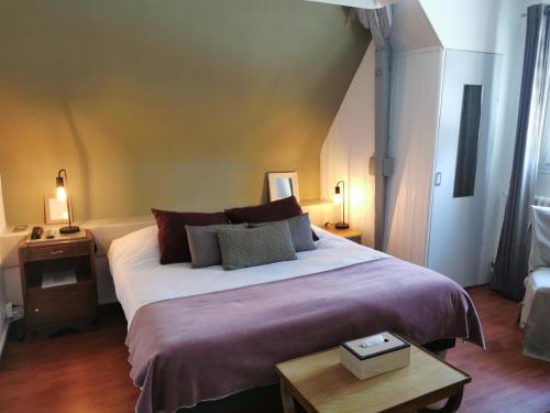 莱蓬德塞果树林餐厅酒店的一间卧室配有一张大床和一张桌子