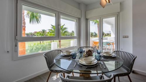 莫特里尔Homity Exclusive Playa Granada Beach & Golf - Marina Golf的一间设有玻璃桌和椅子的用餐室