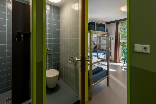 哈莱姆Stayokay Hostel Haarlem的一间带卫生间的浴室和一间带双层床的房间