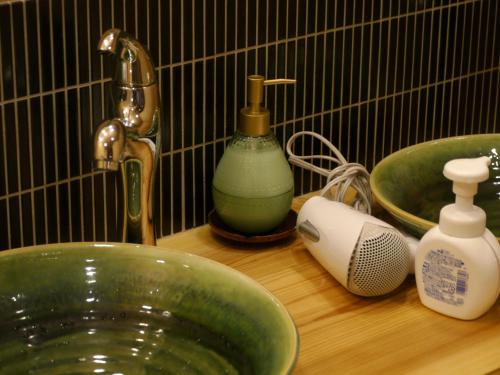 京都祗园旅馆Q-BEH的一个带绿色水槽和水龙头的浴室台面