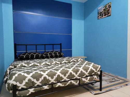 关丹LEBOK HOMESTAY AIRPORT KUANTAN的一间卧室配有一张蓝色墙壁的床