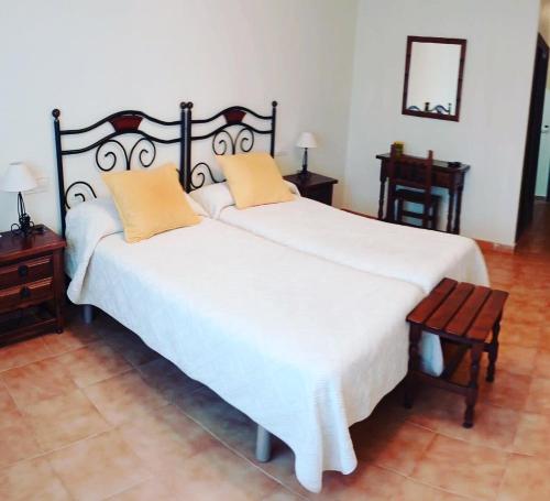 特里弗斯HOTEL AS MACEIRAS的卧室配有带橙色枕头的大型白色床