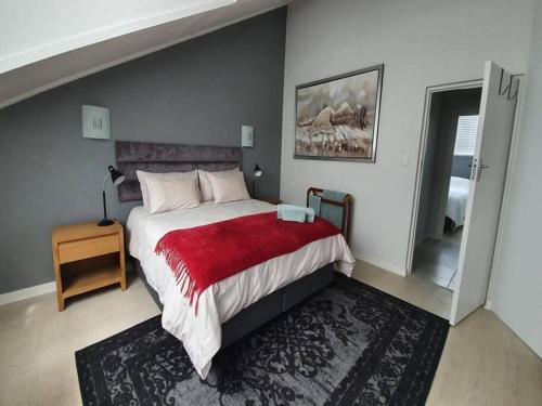 莫塞尔湾Santos Beach Pavilion E的一间卧室配有一张带红色毯子的大床